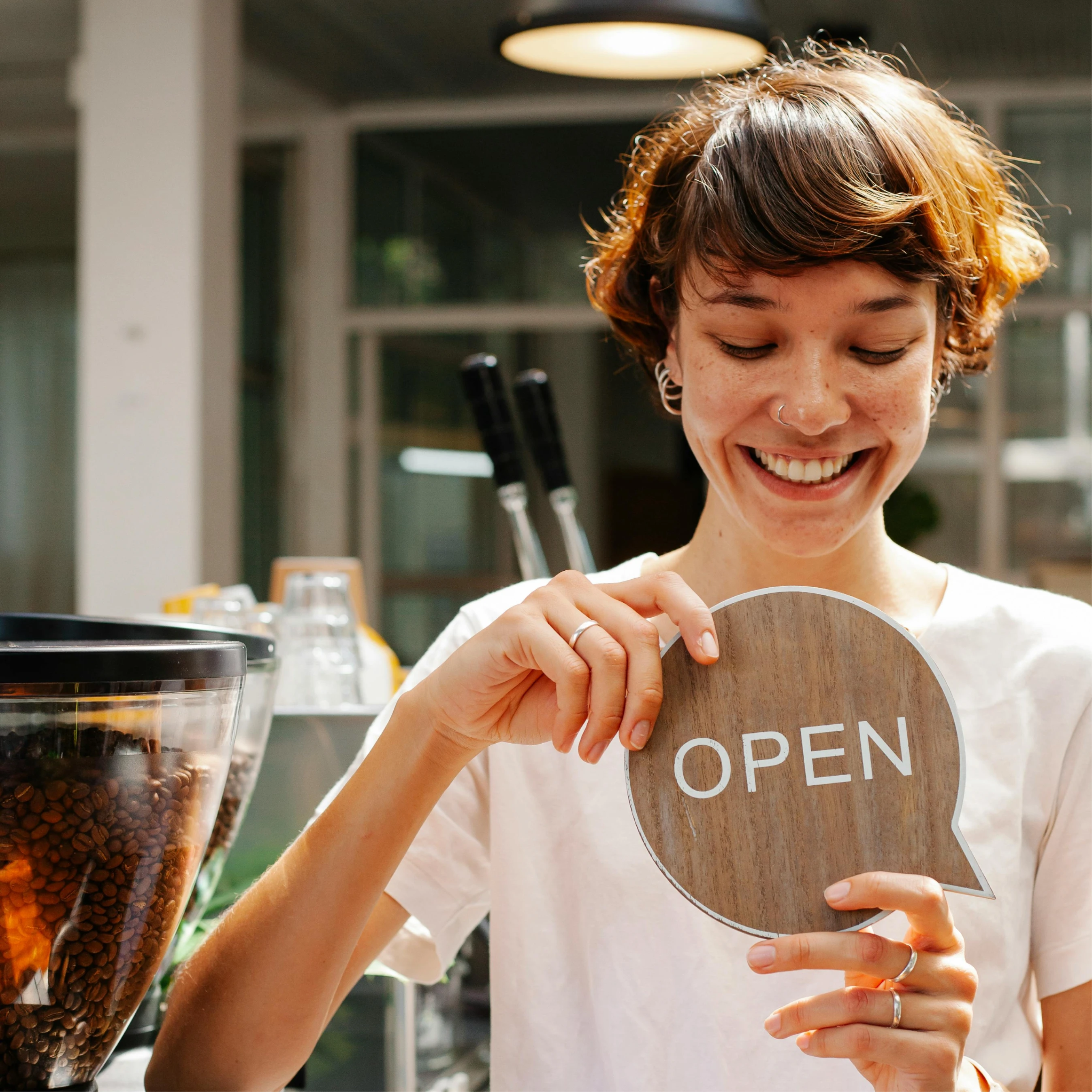 Happy business owner holding an open sign